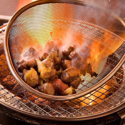 鶏の炭火焼を七輪でお客様が専用ざるを使って本場の薫り高い鶏の燻しを体験！
