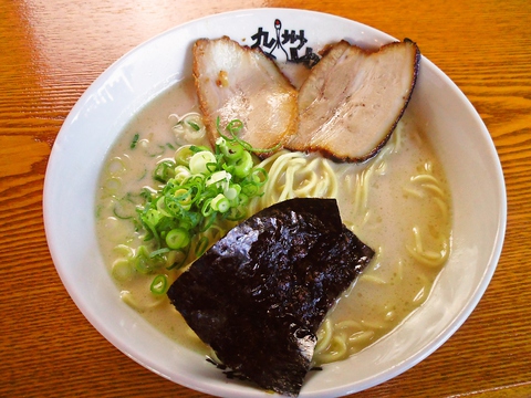 落ち着いた木目調の店内。道路沿いの広いガラスにより開放感のあるラーメン店。