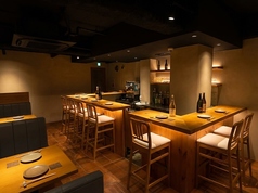 落ち着いた照明と木目の美しいL字カウンターが迎える、大人のための居酒屋。座り心地の良いハイチェアで、料理人の手さばきを眺めながら、ゆったりと一献傾けられます。奥には足を崩して寛げる座敷席も完備。テラコッタ風の床と暖色系の光が、モダンで洗練された雰囲気を演出し、心安らぐひとときを提供