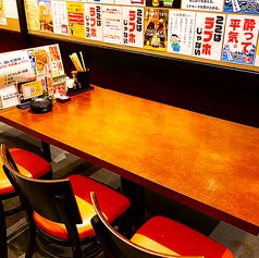 大容量のドリンクボトルが並ぶインパクト抜群のカウンター席。卓上にはメニューや調味料がわかりやすく配置され、すぐに注文しやすい快適なレイアウト。視界の先に厨房が広がる、見ているだけでも楽しい特等席です。