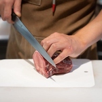 料理人が、塊肉から手切りする姿を見られるカウンター席
