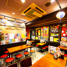 カラフルなポスターと50円レモンサワーの大きな掲示が印象的な、見て楽しい賑やか空間！テーブルが使いやすく配置され、会話が弾む明るい雰囲気が広がります。飲んで食べて笑って、気軽に楽しめる酒場らしさがギュッと詰まった甲府の居酒屋です◎