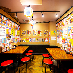 壁には昔ながらのポスターがずらりと並び、赤いスツールと木製テーブルが整然と配置された活気あふれる空間。提灯の柔らかな灯りが店内を照らし、誰でも気軽に入りやすいアットホームな雰囲気を作っています。