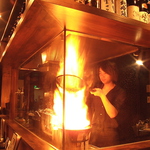 炎が上がった瞬間は店内が盛り上がる！情熱と魂を込めて焼き上げる情熱メニューのさつま知覧鶏もも焼