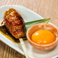 【他では食べられない自慢の鶏料理】大きさの違う３種類の鶏挽肉を混ぜ合わせて作った肉汁たっぷりの特大つくねです。独自の食感を楽しめるよう網脂で包んで香ばしく焼き上げました。贅沢に烏骨鶏の卵を絡めてお召し上がり下さい。
