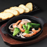 プリプリのえびといかを楽しめる海鮮アヒージョ。濃厚な旨みとバゲットの香りが絶妙にマッチした一品