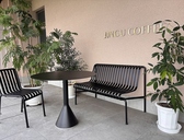 「JINGU COFFEE」のロゴと緑に囲まれた心地よいベンチスペース。天気の良い日にはテラス席としてもご利用いただけます。愛犬と一緒のランチタイムや、お散歩途中のカフェタイムにもぴったり。心地よい外の風を感じながら、ゆったりとお過ごしください。