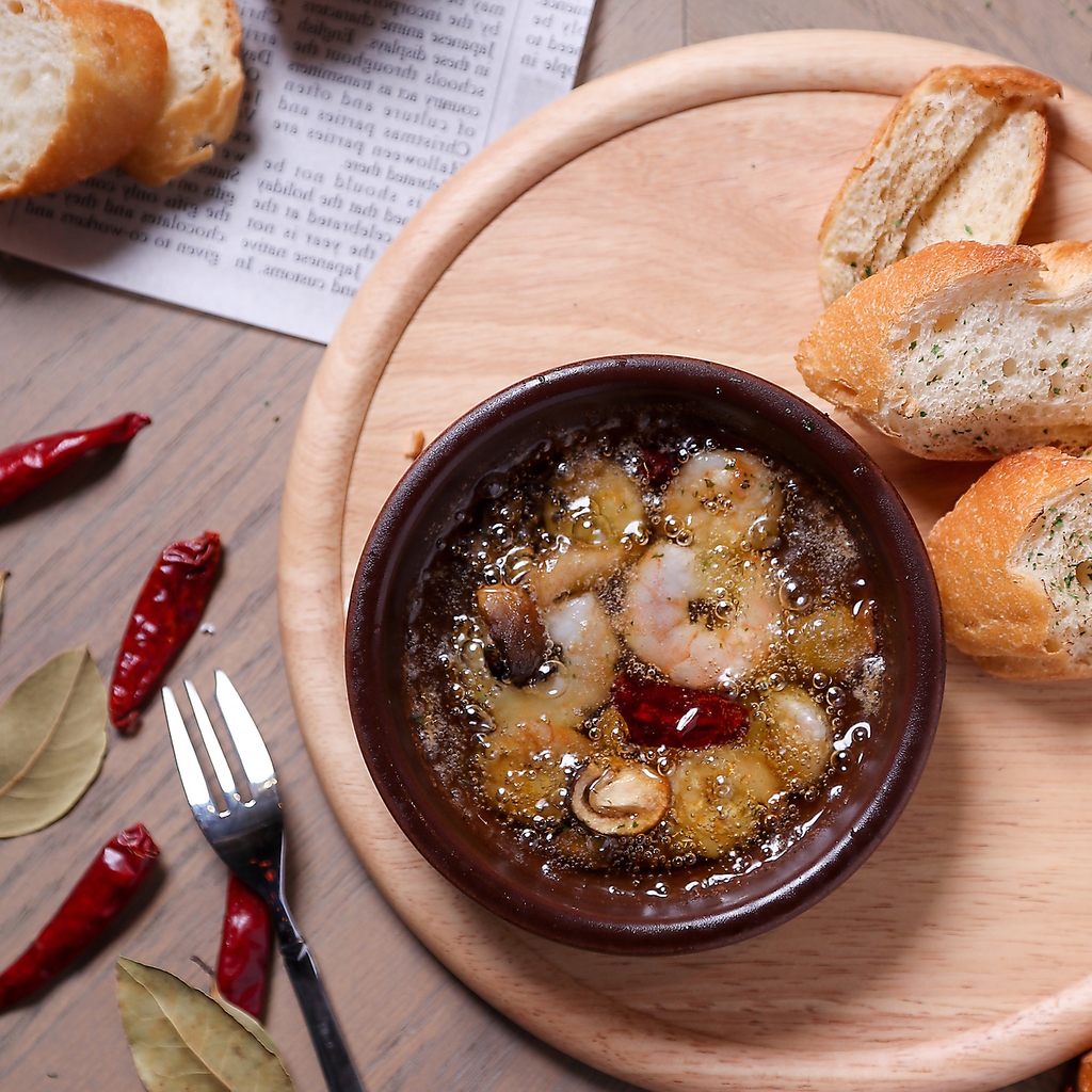 大人気の海老とキノコのアヒージョ。バゲットに旨味が凝縮されたオイルをつけてお召し上がりください