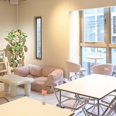 【2階】テーブル席。白いお部屋にピンクの家具を取り入れたかわいい空間になっています！淡いピンクを使用していて、１階とは雰囲気の異なる空間をお楽しみいただけます！