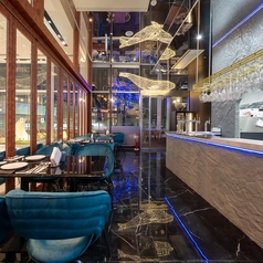 【洗練された青の空間で贅沢なイタリアンを】食材の色彩を引き立てる照明が当店自慢の料理をより一層華やかに演出します。仲間内で会話しやすい程よい広さも魅力。有楽町の夜景を臨む大きな窓と高い天井が演出する唯一無二の空間で、美味しいワインを片手に、心ゆくまで女子会や語らいをお楽しみください。