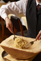 料理メニュー写真 パルミジャーノ・レジャーノの器で和えたスパゲティ又はリゾット メッツァニィノ風