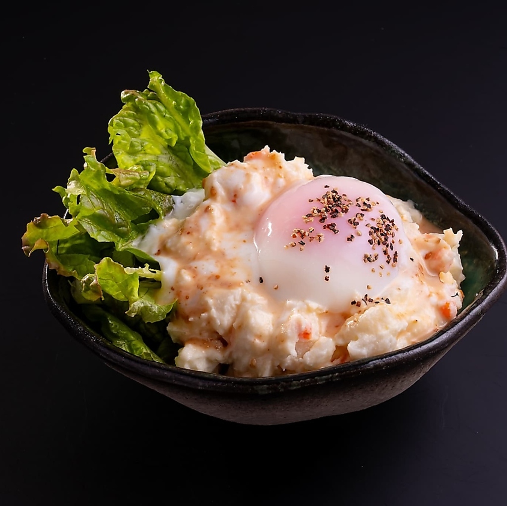 クリーミーな温玉ポテトサラダは絶妙な味わいでサイドメニューを引き立てます。ぜひお試しください！