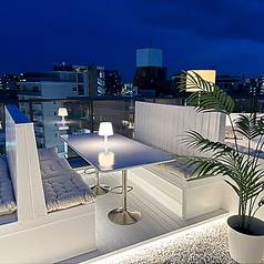 【テラス:テーブル】テラス壁側の席は、街の灯りをガラス越しに静かに眺められる特等席。柔らかな卓上灯と足元の間接光が手元を美しく照らし、会話に集中できる穏やかな距離感。デートはもちろん、複数人でも写真映え抜群です。