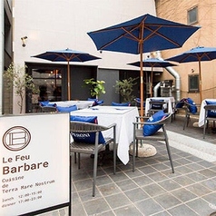【テラス席】心地よい風を感じるLe Feu Barbareの開放的なオープンテラス。ランチタイムから夜のビアガーデン利用まで、幅広いシーンで活躍する特等席です。都会の喧騒を離れた洗練された空間で、自慢の香ばしい薪火焼き極上肉や新鮮な生牡蠣を味わいながら、五感を満たす特別なひとときをお過ごしください。