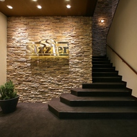 茶と間接照明を基調とした、落ち着いた店内へと誘います