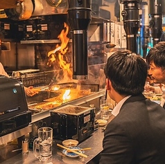 カウンター席では、目の前で豪快な炎が上がるライブ感あふれる調理風景をお楽しみいただけます。熟練のシェフがお魚を焼き上げる様子は迫力満点！五感を刺激する特等席です。