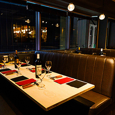 開放感あふれる一面の大きな窓が特徴の店内は、明るく広々とした空間。カジュアルなテーブル席で気軽にステーキとワインを楽しめる雰囲気です。