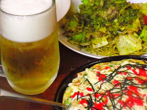 カウンターの鉄板で店主が焼く。熱々のお好み焼きと焼きそば、ラーメンが楽しめる。