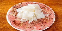 皿一面に広がる牛肉のカルパッチョ　ふわふわチーズがけ
