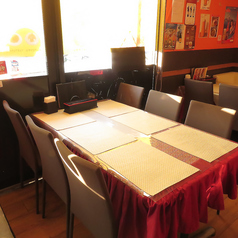 店内はレンガ調の壁や鮮やかなオレンジ色の壁で装飾され、異国情緒あふれる雰囲気の中で食事が楽しめます。情熱的な赤色のテーブルクロスが目を引くテーブル席です。