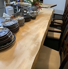 古いもので江戸時代に焼かれた骨董皿が並ぶ栃の木の一枚板カウンター