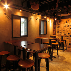 【1階】スペインバル席は、13名から20名様までの貸切に最適な空間です。カジュアルでありながらもスタイリッシュなデザインが特徴で、友人や同僚との集まりにぴったりです。高めのテーブルと座り心地の良いスツールが配置され、リラックスしながら楽しいひとときをお過ごしいただけます。