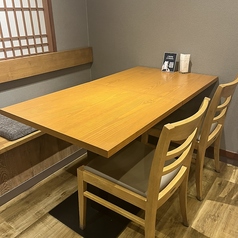木を基調とした和の空間に配されたテーブル席は、落ち着いた雰囲気の中でゆっくりと食事を楽しめるお席です。ご友人同士やご家族、少人数での会食に最適で、ランチの定食から夜の宴会利用まで幅広くご利用いただけます。会話を楽しみながら、心地よい時間をお過ごしください。