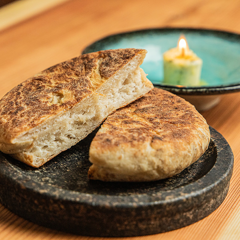 【灯るハーブバターの蝋燭と共に】オーダー後に発酵させ、薪と炭で焼き上げる◆◇自家製フォカッチャの写真