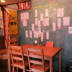 落ち着いた雰囲気のテーブル席。左手の黒板には、日本酒の銘柄がずらり。