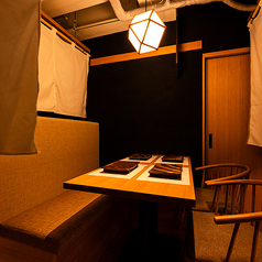 【ゆったり落ち着けるテーブル席】くつろぎのひとときを。程よい距離感と心地よい照明に包まれたテーブル席はゆったりと落ち着いてお過ごしいただける空間です。ご友人との食事やご家族との団らん、接待や会食など、様々なシーンに対応可。会話を楽しみながら、炭火焼きの香ばしさと素材の旨みをじっくりとご堪能ください。