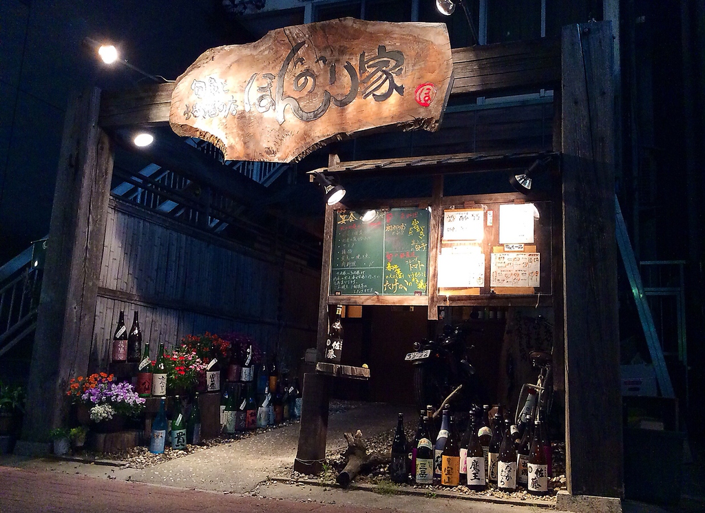 外には日本酒・冷酒のビンがゴロゴロと並び、歩く人を釘付けに…☆ほんのりと明るい入口です。