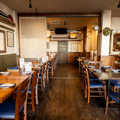 ぬくもりある木製家具と鮮やかなブルーの椅子が調和する、開放的なダイニング。店内には本格的なピザ窯が鎮座し、職人が一枚ずつ丁寧に焼き上げるライブ感を間近で楽しめます。カウンターに並ぶワインやビア樽が賑やかな夜を演出し、日常を忘れてゆったりと本格イタリアンを堪能できる空間です。