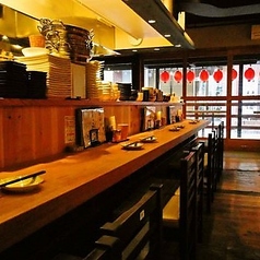 当店は、温かみのある木のカウンターと和風の装飾が特徴です。赤い提灯が店内を明るく照らし、落ち着いた雰囲気を醸し出しています。多様な焼鳥を楽しめる場所で、食事をしながらリラックスできる空間です。
