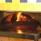 専用の石釜で１枚１枚丁寧に焼き上げるピザは、端までパリパリ！桜とクヌギの薪を使い、独特の風味に仕上げます。